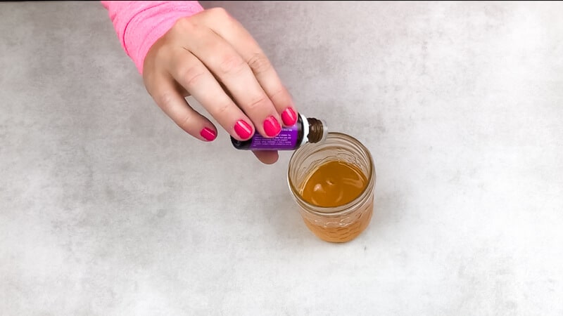 Adding drops of lavender essential oil to shea butter baby balm recipe