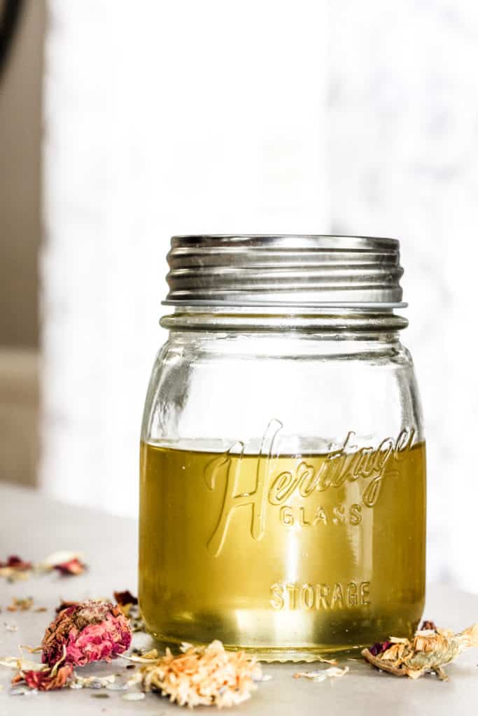 How to Quickly Make Herbal Infused Carrier Oils: Rose, Lavender and Calendula herbs being infused in a jar of carrier oil.