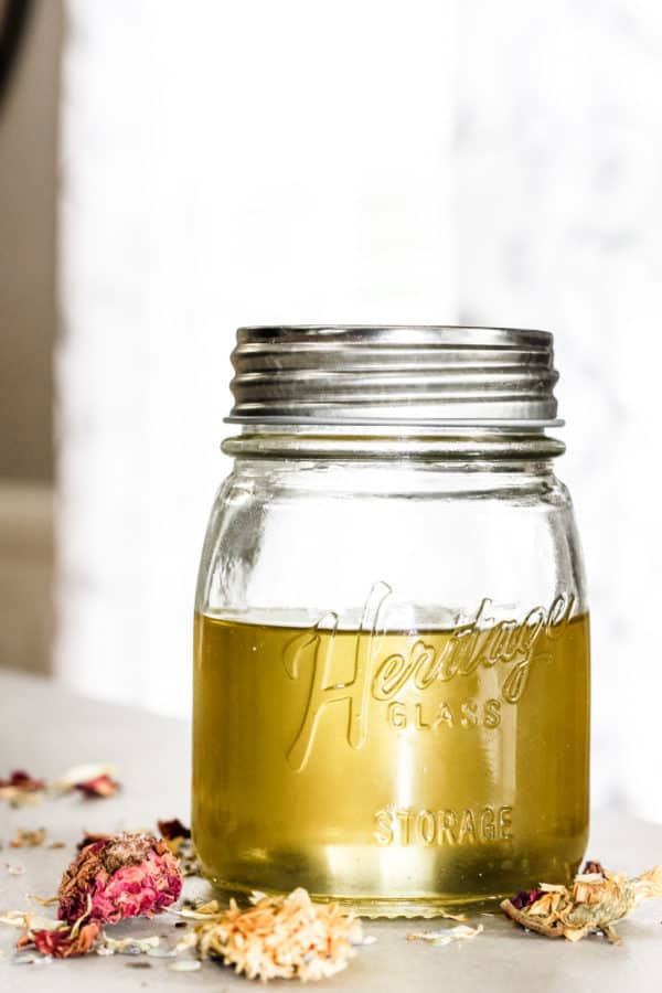 How to Quickly Make Herbal Infused Carrier Oils: Rose, Lavender and Calendula herbs being infused in a jar of carrier oil.
