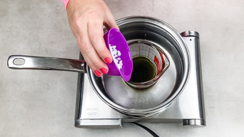 adding ingredients for diaper rash cream into pan on stove