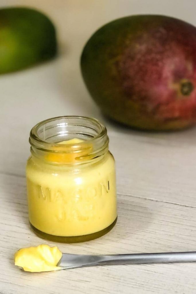 mango and jar of whipped mango body butter with spoon