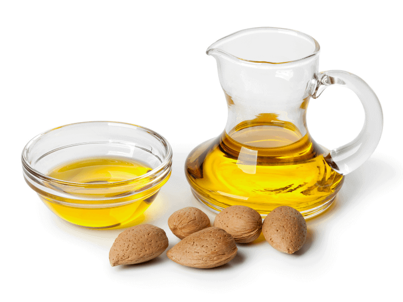 Almond oil in pitcher and bowl with almonds